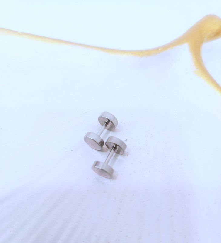 Par de aretes de acero plateados con circulo giratorio