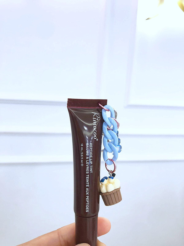 Lip gloss con charm dupe de Rhode tono café oscuro